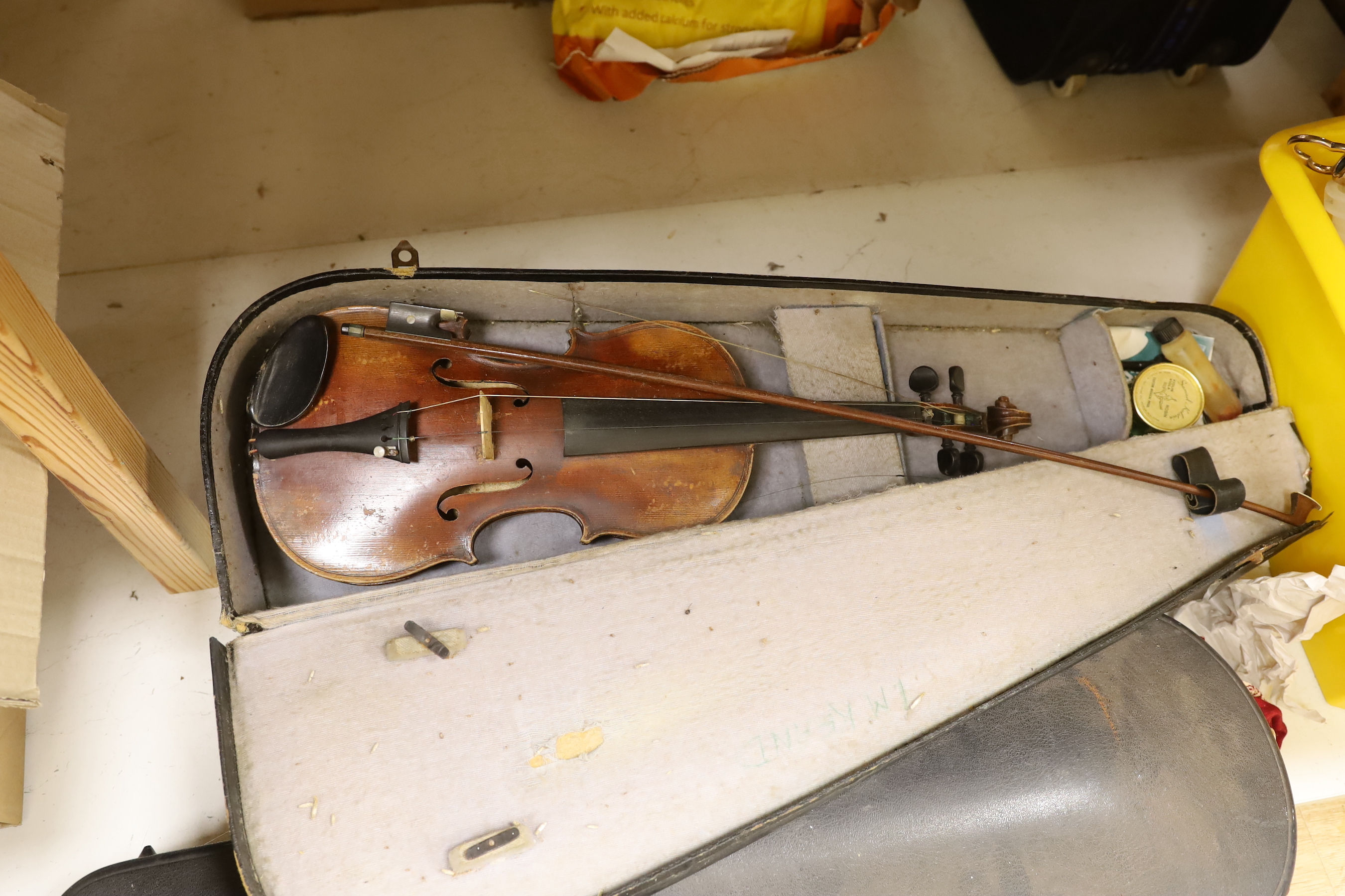 A violin, labelled Giovan Paulo Maggini, and three other violins, with bows in cases